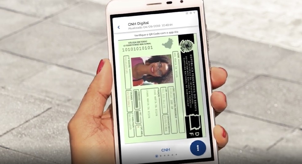 Smartphone displaying a digital CNH driver's license inside the eCNH app, showing document details and photo